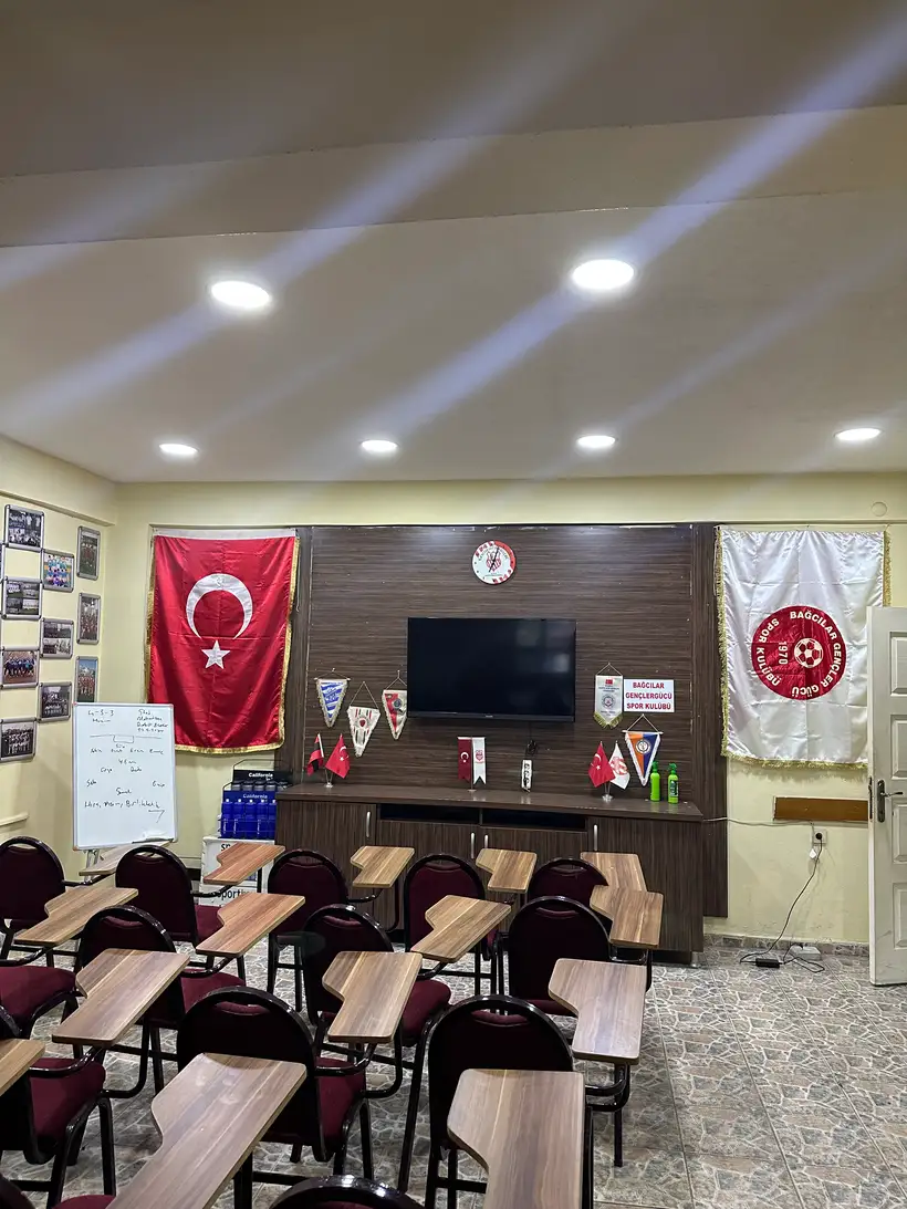 Kulüp lokali — bayraklar, flamalar, whiteboard ve çerçeveli takım fotoğrafları